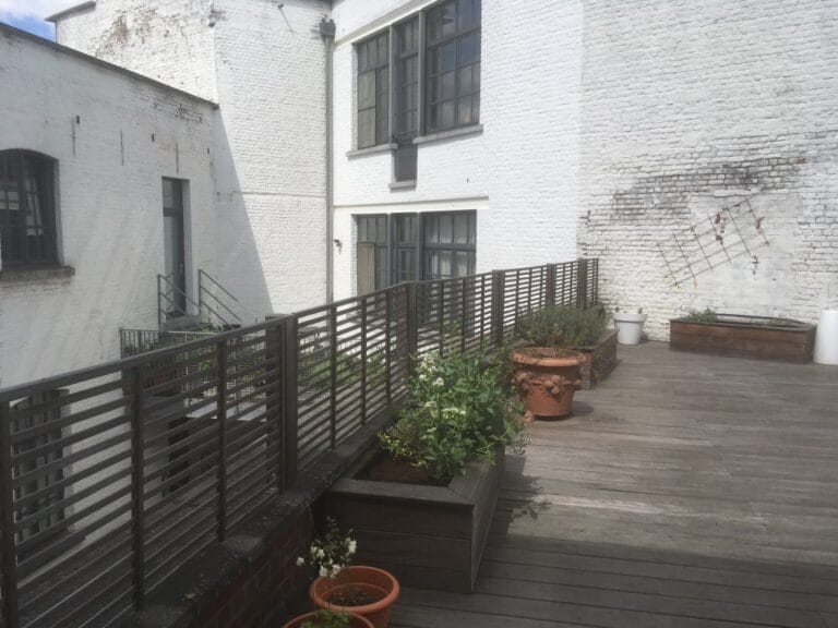 Terrasse en bois de Cumaru fraîchement installée dans un jardin résidentiel, illustrant les bois exotiques utilisés pour les aménagements extérieurs durables.